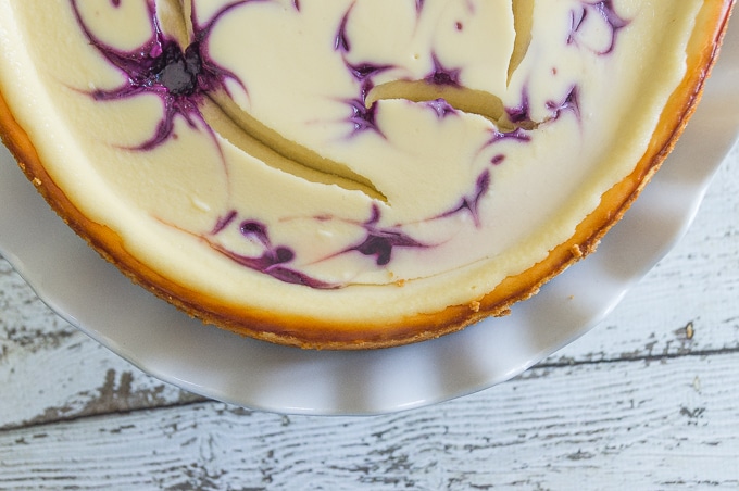 A flat overhead shot of part of a Blueberry Swirl Cheesecake, clearly showing a series of lovely blueberry swirls.